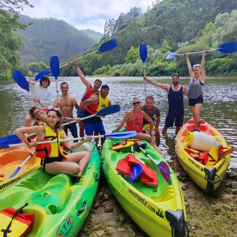 Grupo de personas posando con las canoas
